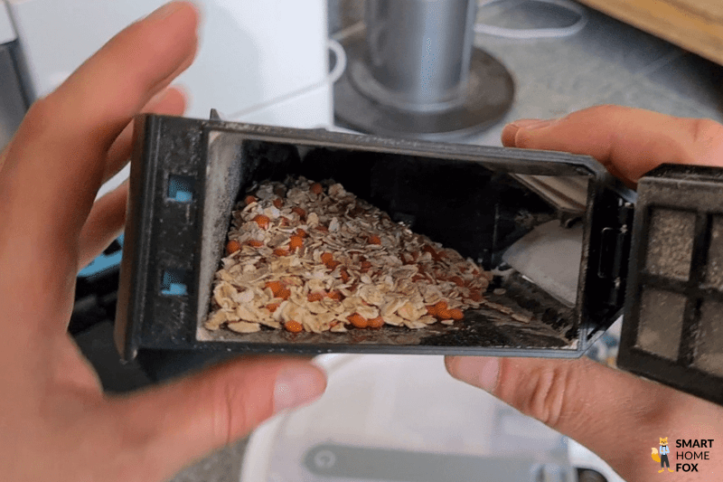 Der Inhalt des mobilen Staubbehälters des Yeedi Cube ist in der Nahaufnahme zu sehen.